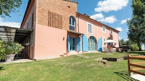 A two-story building with a brick facade, a flat roof, and a small front garden.