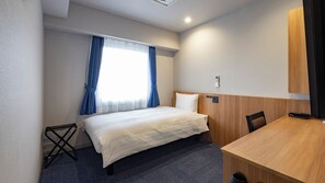 A hotel room with a bed, a desk, a chair, a small table, and a window with curtains. - Toyoko Inn JR Uji-eki Minami-guchi (Uji)