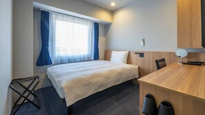 A hotel room with a bed, a desk, a chair, a mirror, and a window with curtains. - Toyoko Inn JR Uji-eki Minami-guchi (Uji)