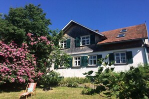 A two-story house with a sloped roof, green shutters, and a white exterior. - Holiday home with 1 bedroom (Wutach- Münchingen)