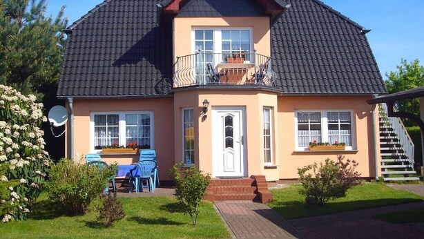 A two-story house with a balcony, a front door, and a small front yard. - Holiday apartment in Alt-Reddevitz with Wi-Fi (Alt-Reddevitz)