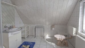 A small, compact bathroom with a toilet, sink, and storage cabinet. - Holiday apartment in Alt-Reddevitz with Wi-Fi (Alt-Reddevitz)