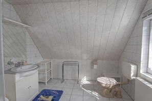 Un baño pequeño y funcional con inodoro, lavabo y armario para almacenamiento.