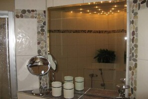 A bathroom with a mirror, a sink, and a shower area. - Lakeside idyll Comthurey - Reed House (Wokuhl-Dabelow OT Comthurey)