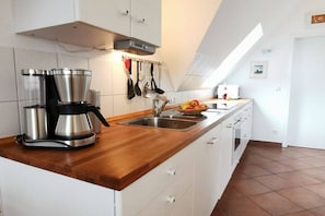 A modern kitchen with a built-in stove, a coffee maker, and a sink. - Holiday apartment with 2 bedrooms (Prerow)