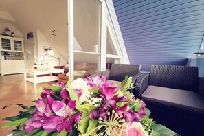 A living room with a sofa, a coffee table, and a large window. - Holiday apartment with 2 bedrooms (Prerow)