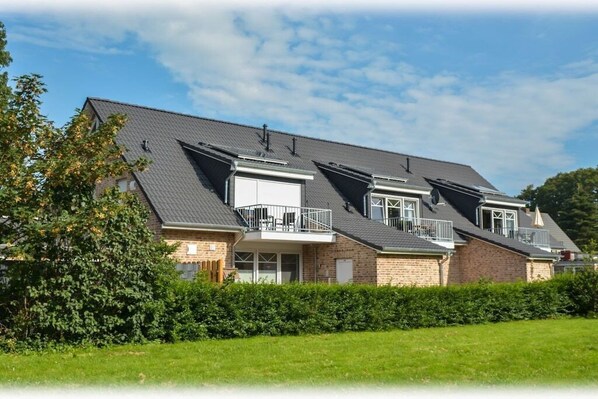 A residential building with multiple balconies, a brick facade, and a flat roof. - Holiday apartment with 2 bedrooms (Norden)