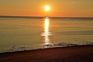 A beach scene with a sunset over the ocean. - Holiday apartment with 2 bedrooms (Norden)