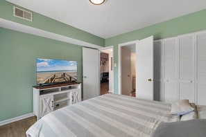 A bedroom with a bed, a television on a stand, and a closet. - Glenn's Bay Retreat Surfside Beach (Surfside Beach)