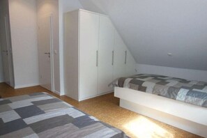 Une chambre à coucher avec un lit, une armoire et un plafond en pente.