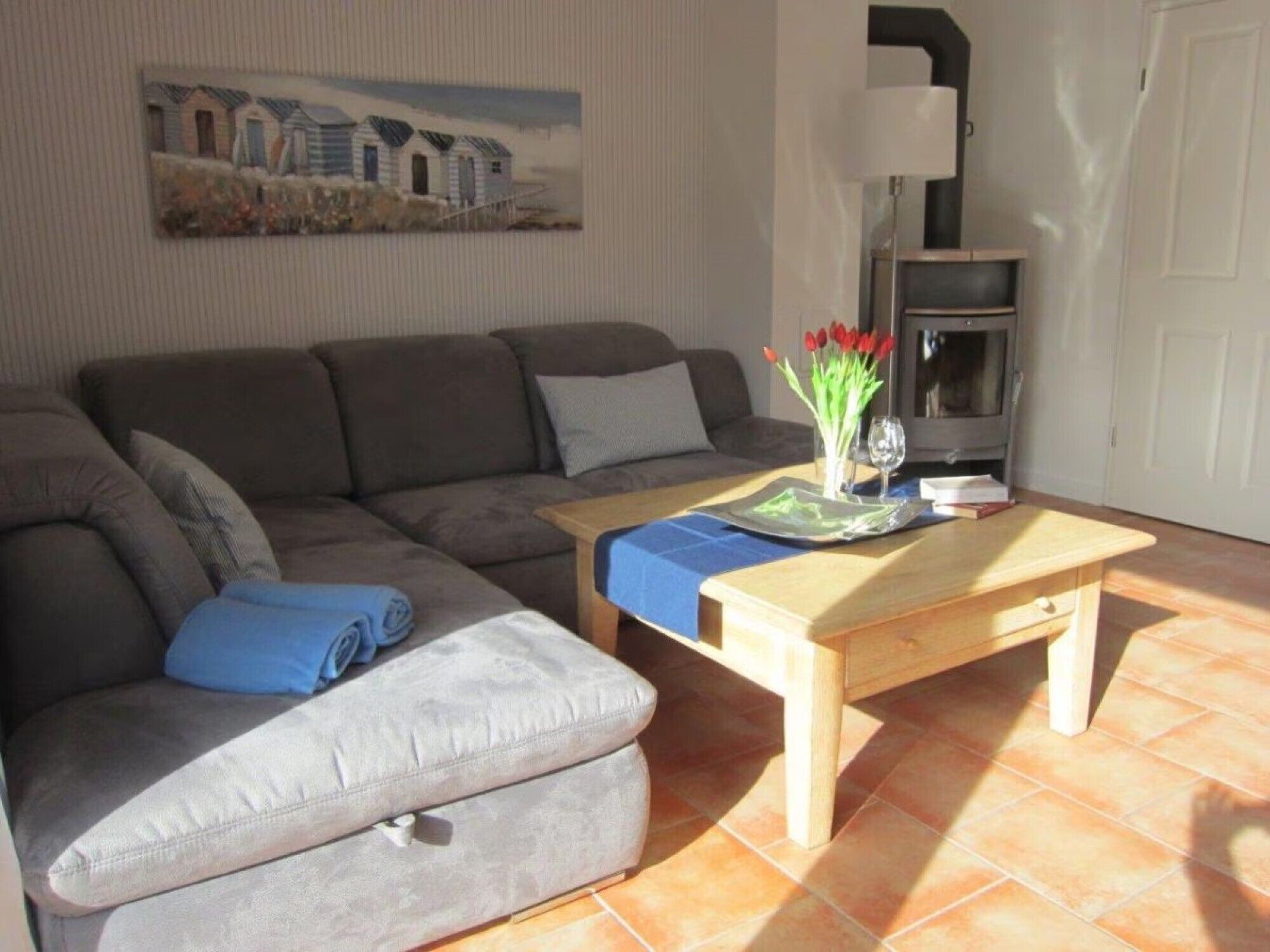 Ein Wohnzimmer mit einer Couch, einem Couchtisch, einer Lampe und einem Gemälde an der Wand.