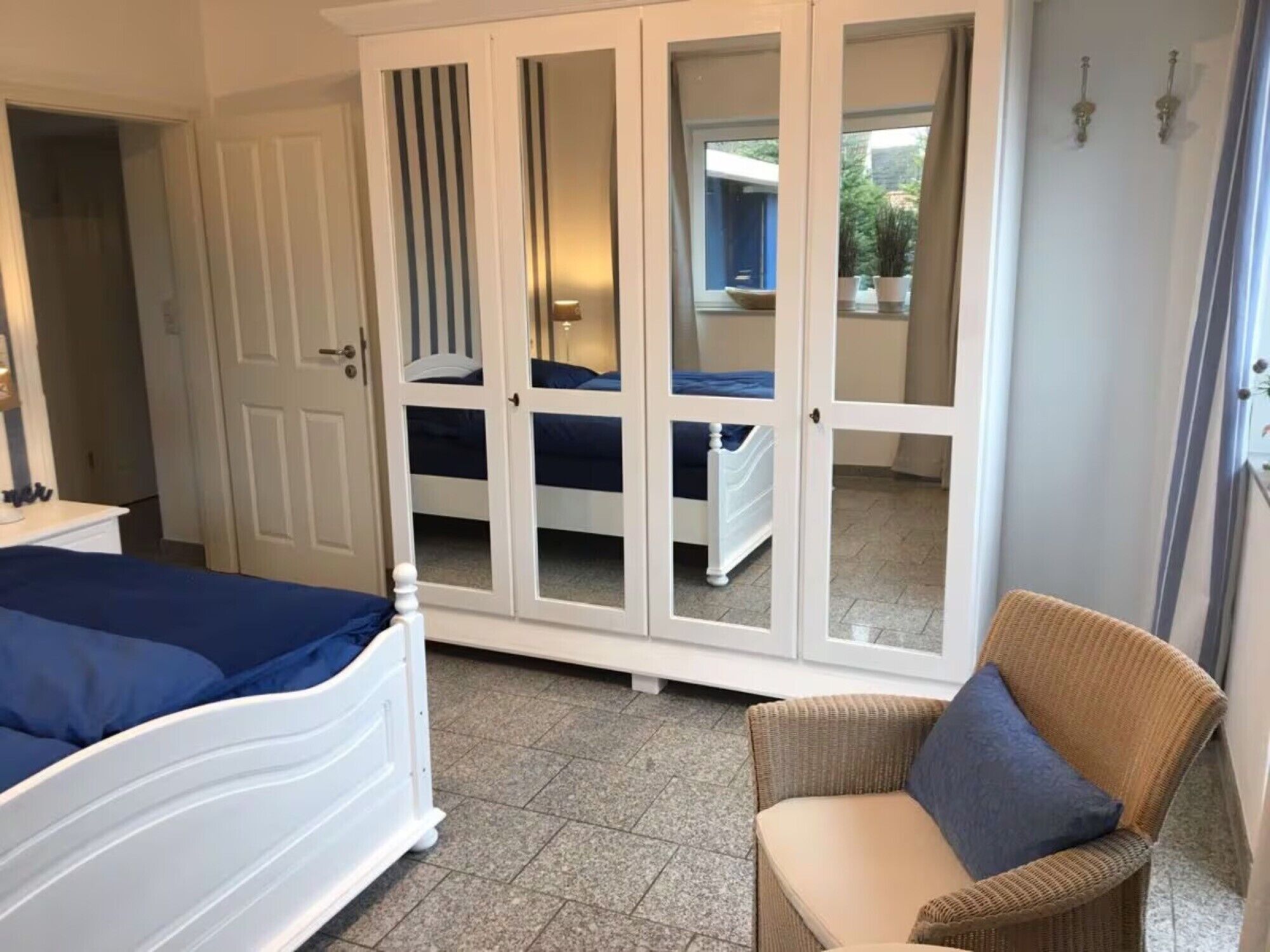 Une chambre à coucher comprenant un lit, une chaise et une armoire aux portes miroir.