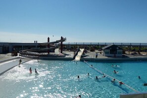 A swimming pool with a water slide and a lifeguard station. - Wattkieker de Ool in the Vitamar holiday park (Wurster Nordseeküste)