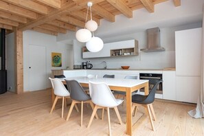 A modern kitchen with a central island, white cabinets, and a hanging light fixture. - Bioclimat wooden house in the countryside (Messanges)