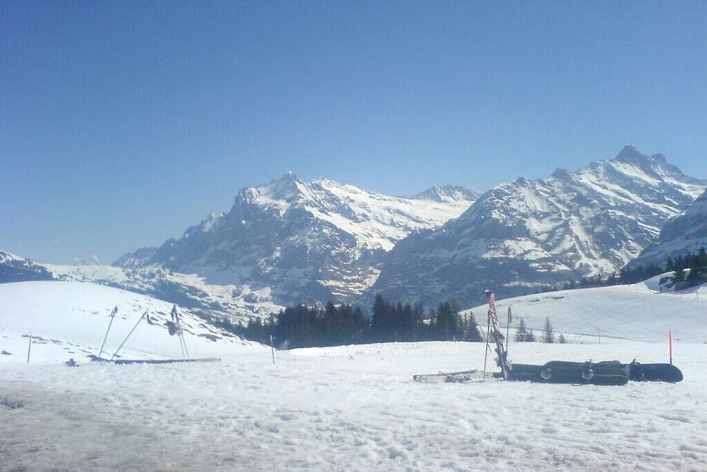 Een besneeuwd berglandschap met ski-uitrusting en een heldere lucht.