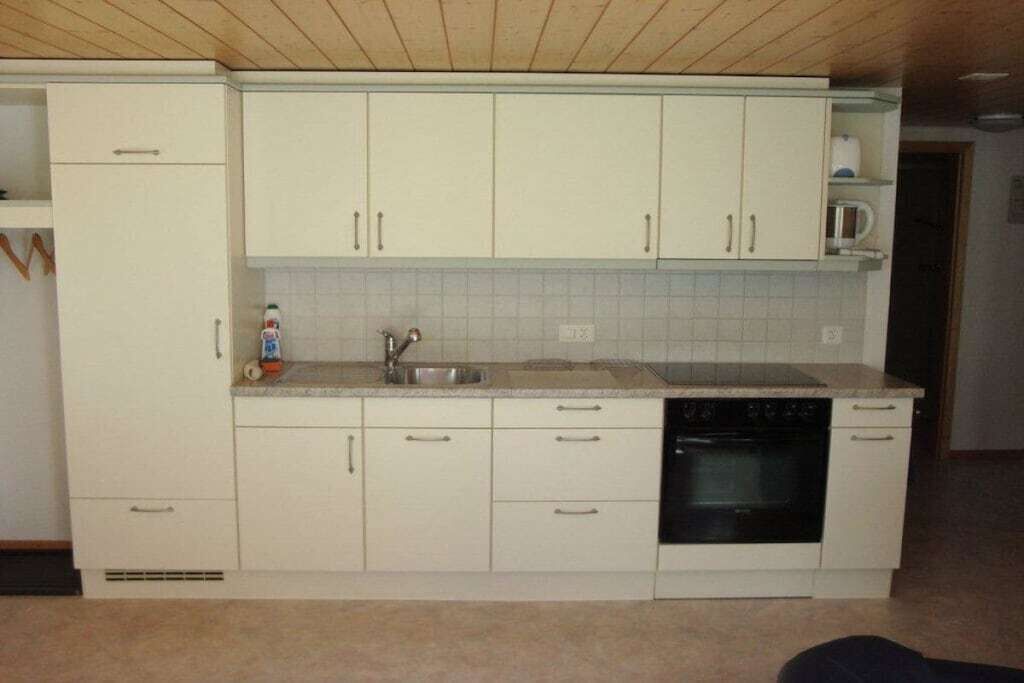 Eine Küche mit weißen Schränken, einem Geschirrspüler und einer Mikrowelle.