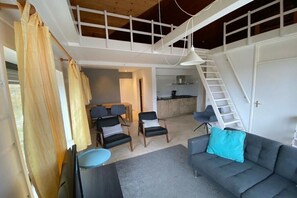 A spacious living area with a high ceiling, a staircase, and a kitchen in the background. - Cabin in Makkum with swimming pool (Makkum)