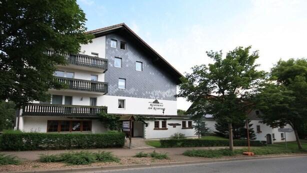 Um edifício de dois andares com uma placa indicando que é uma residência.