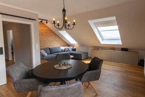 A modern loft with a dining area, a loft bed, and a kitchen. - Small spruce tree with balcony (Braunlage)