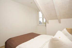 A bedroom with a bed, a window, and a sloped ceiling. - Near the beach, balcony, ocean view, Dranske beach vacation rentals, Vacation Rental 26 (Dranske)
