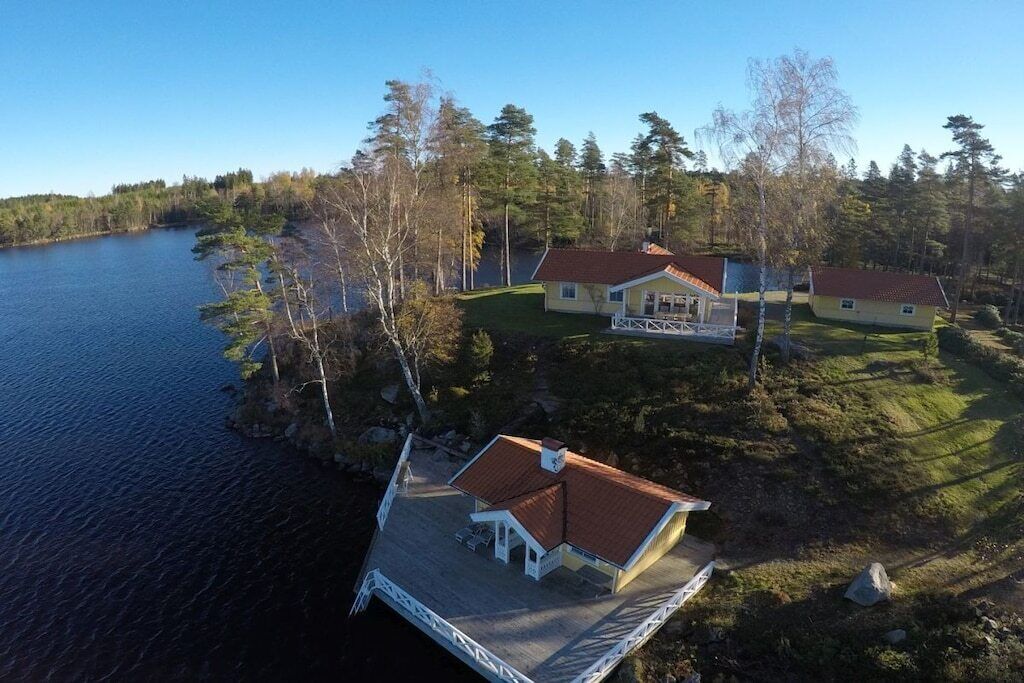 Une propriété située au bord du lac, comprenant un quai, une maison principale et un bâtiment plus petit.