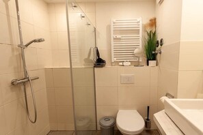Ein kleines Badezimmer mit Dusche, Toilette und Badewanne.