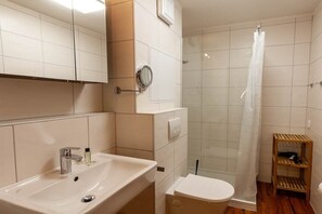 Ein Badezimmer mit Waschbecken, Toilette und Dusche.