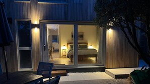 Ein modernes Gebäude mit Glastür-Eingang, der zu einem Schlafzimmer mit Bett und Nachttisch führt.