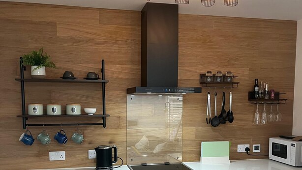 Eine moderne Küche mit Einbauofen, Mikrowelle und Kaffeemaschine.