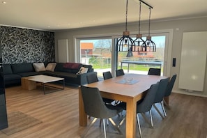 A modern living room with a sofa, coffee table, and dining table with chairs. - |---Harz Mountains---| (Sankt Andreasberg)