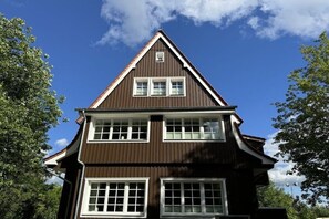 Un bâtiment à deux étages, doté d’un toit à pignon et de nombreuses fenêtres.