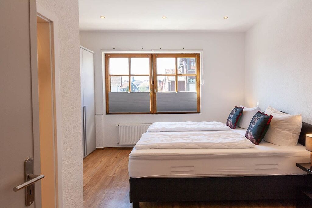 A bedroom with a bed, a window, and a radiator.