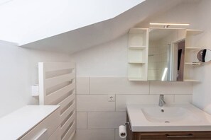 A modern bathroom with a white sink, mirror, and towel rack. - Eye-catching with a dream view (Braunlage)