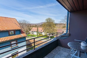 Un balcon avec une balustrade en métal, une table et une chaise.