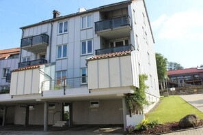 A multi-story residential building with balconies, a covered entrance, and a small garden area. - Brocken summit with terrace (Schierke)