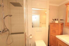 Une salle de bain avec une douche, des toilettes et un lavabo.
