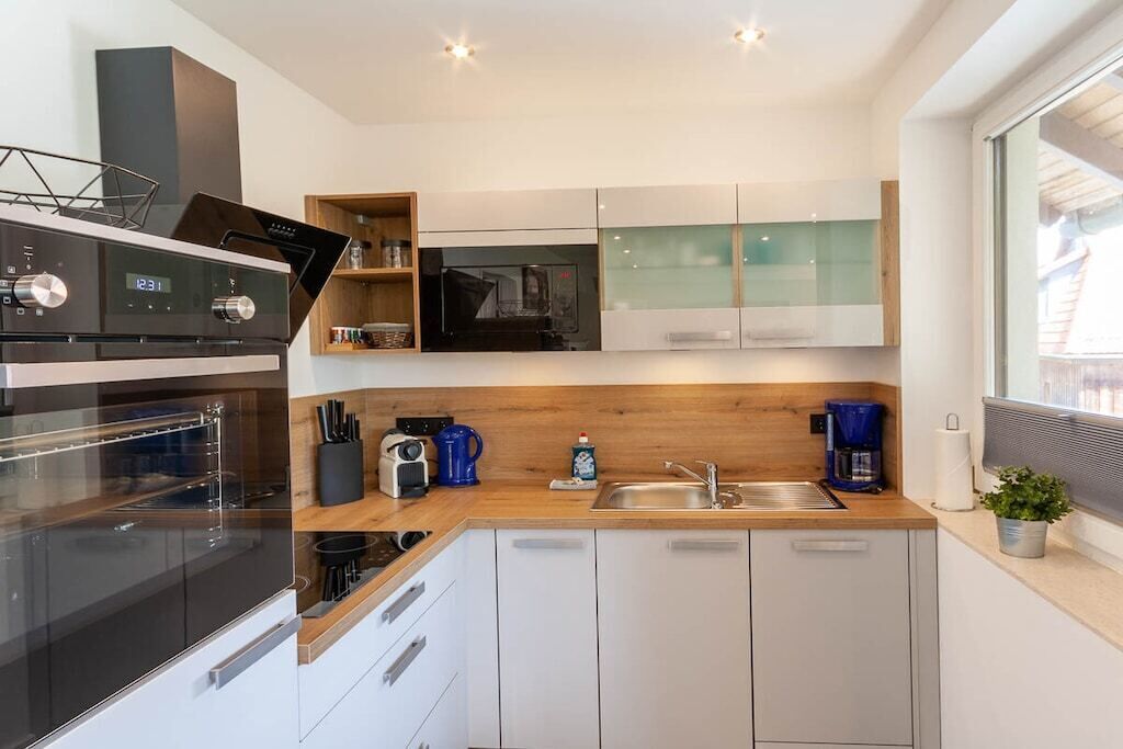 A modern kitchen with a built-in oven, microwave, and coffee maker.
