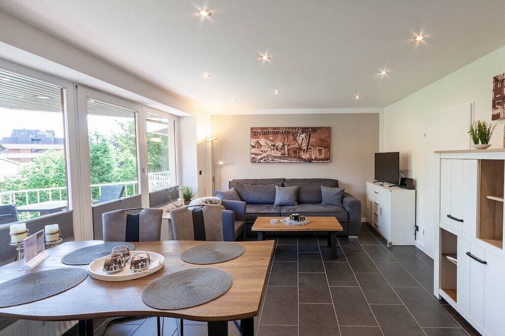 A modern living room with a sofa, coffee table, and dining area with placemats.
