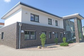 A modern building with a flat roof, large windows, and a brick facade. - Holiday apartment with 3 bedrooms (Dangast)