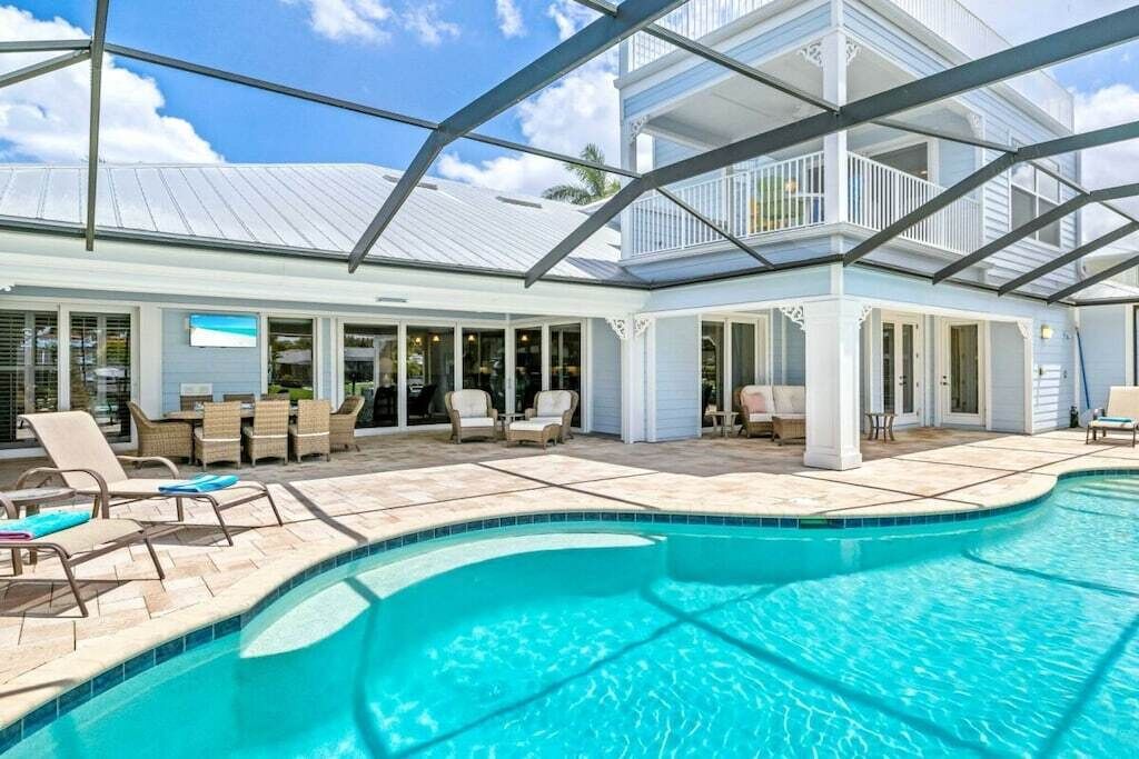 A pool area with lounge chairs and a covered patio.