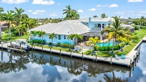 Imóvel à beira-mar com piscina, cais e barco.