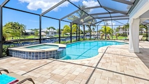 Piscina exterior coberta com hidromassagem, rodeada por um espaço de pátio com espreguiçadeiras.