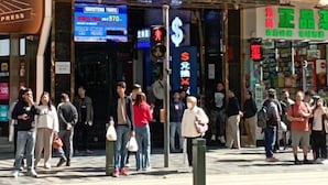 Una calle concurrida con un letrero llamativo que dice 'CHUNGKING MANSIONS'.