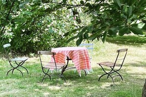 An outdoor seating area with metal chairs and a table covered by a checkered cloth. - Holiday Farm Smokehouse 3 (Wittendörp\/OT Karft)