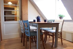 A dining area with a table and four chairs, a blue teapot, and two cups on the table. - Holiday Farm Smokehouse 3 (Wittendörp\/OT Karft)