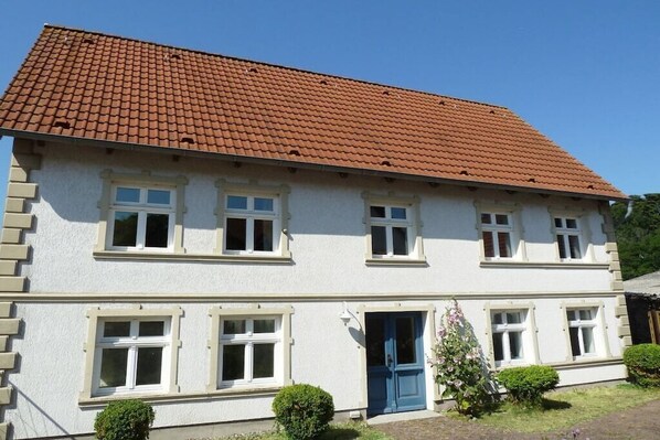 A two-story building with a red-tiled roof, white walls, and multiple windows. - Holiday apartment in Wiek with Wi-Fi (Wiek)