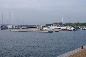 A marina with multiple boats docked, a small building, and a clear sky. - Holiday apartment in Wiek with Wi-Fi (Wiek)