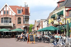A street with outdoor seating, bicycles, and brick buildings. - Wellness Superior 6/8-P (DEURNINGEN)