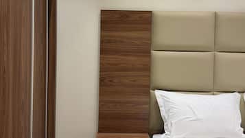 A bedroom with a wooden nightstand, a bed with a headboard, and a wardrobe.