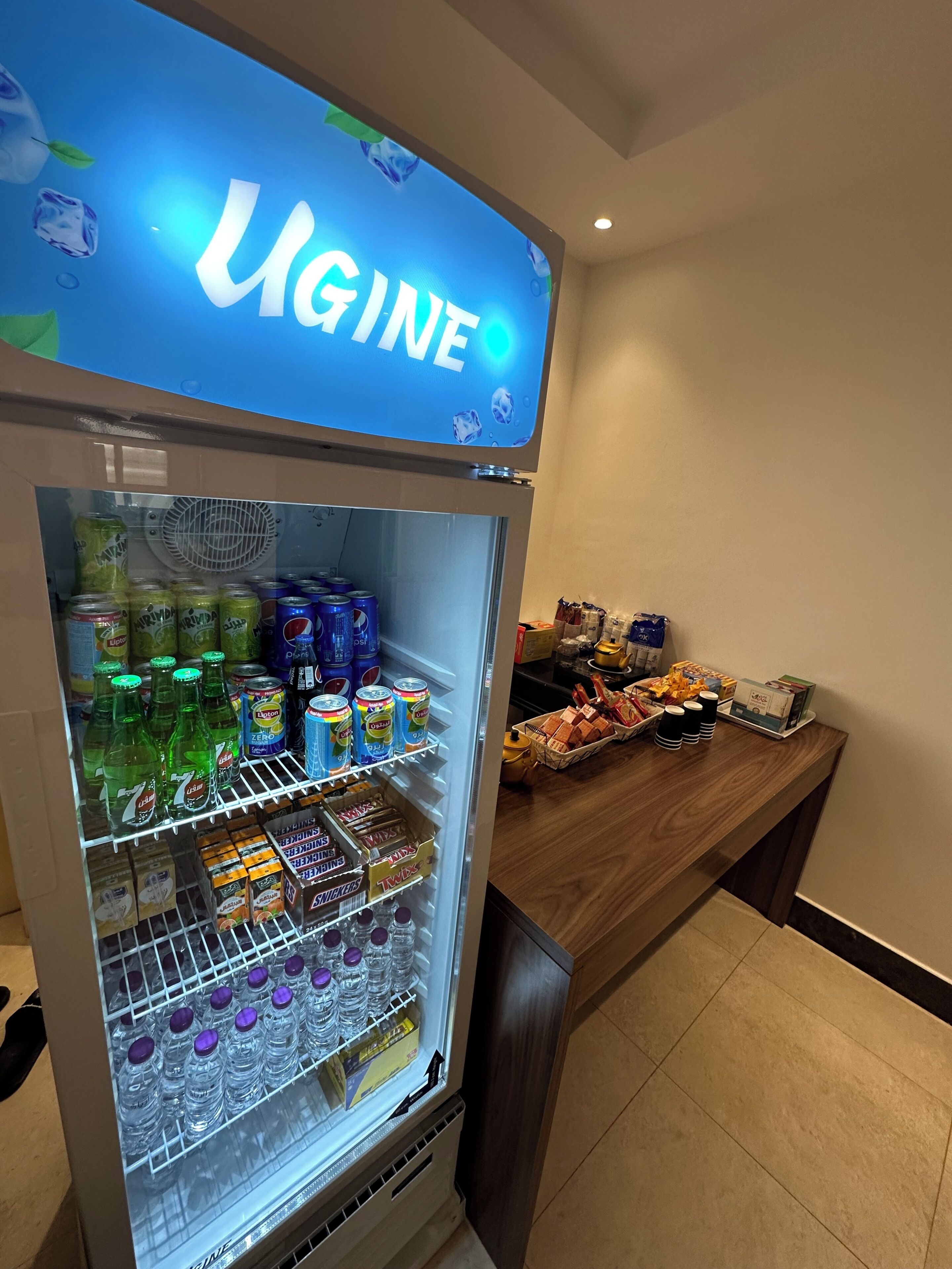 Una màquina expenedora de begudes amb diverses opcions, com ara refrescos i aigua embotellada.
